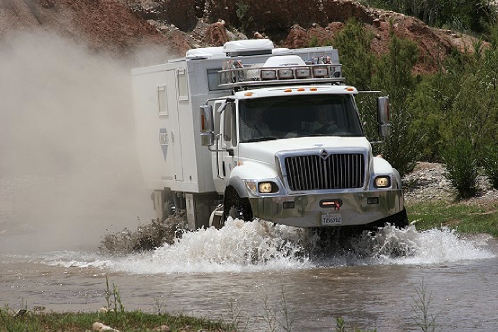 UNICAT expedition vehicle crossing water in desert terrain
