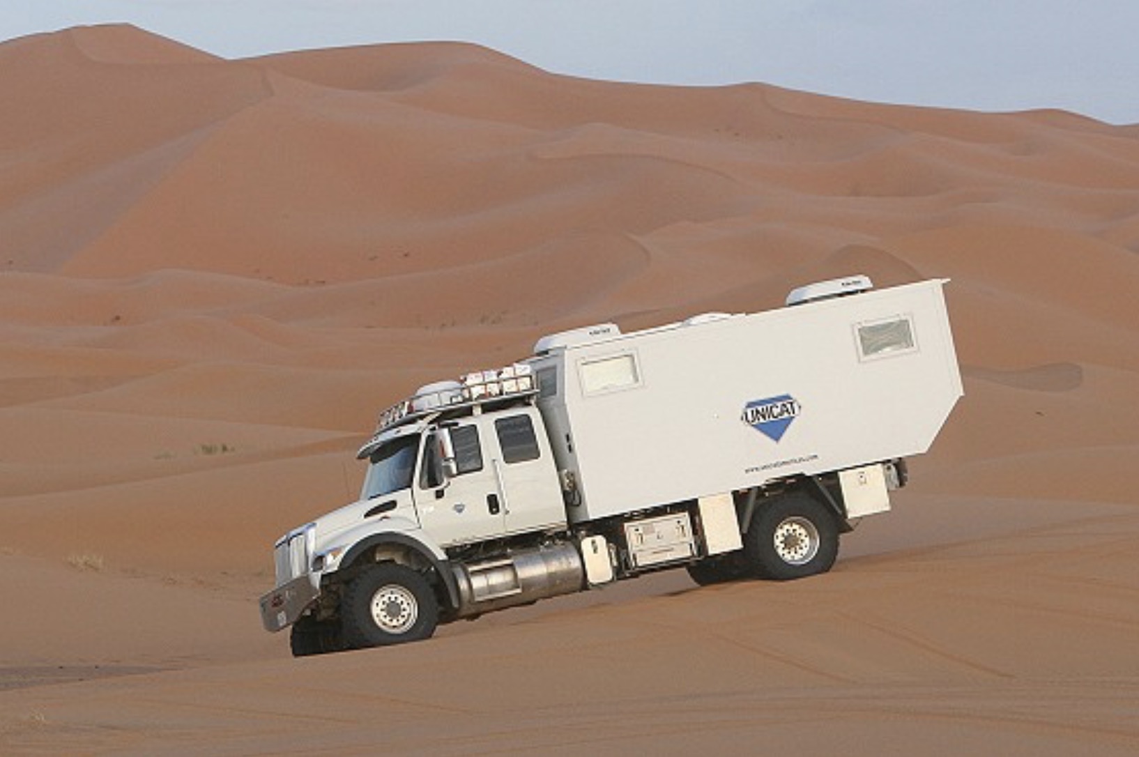 UNICAT expedition vehicle crossing desert dunes